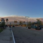 City street with smoke cloud on the horizon