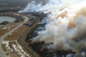 Aerial of a Prescribed fire burning near a neighborhood