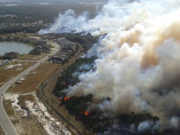 Aerial of a Prescribed fire burning near a neighborhood