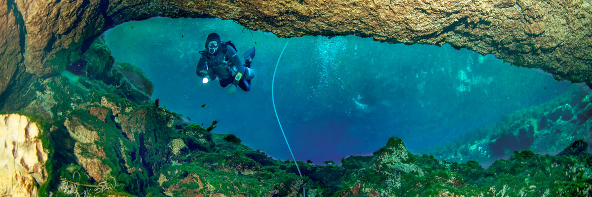 Scuba diver entering a cave