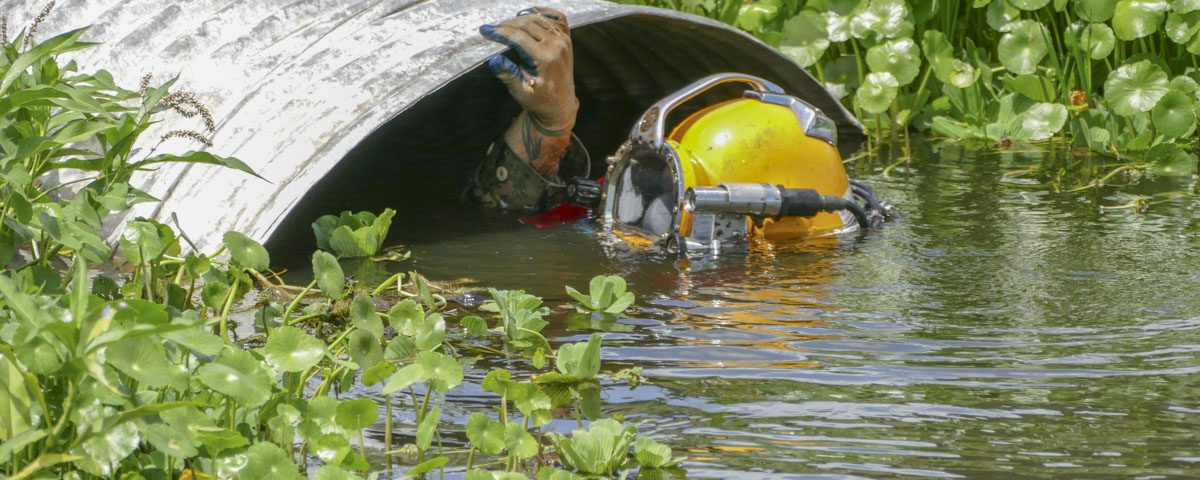 A diver inspecting a large culvert