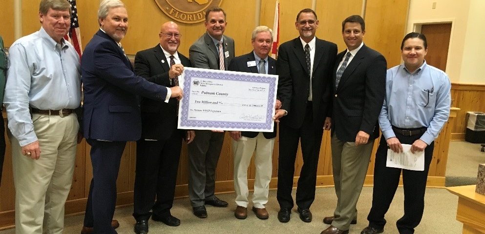 Jim Troiano and Putnam County commissioners and staff with a cost-share check at a commission meeting