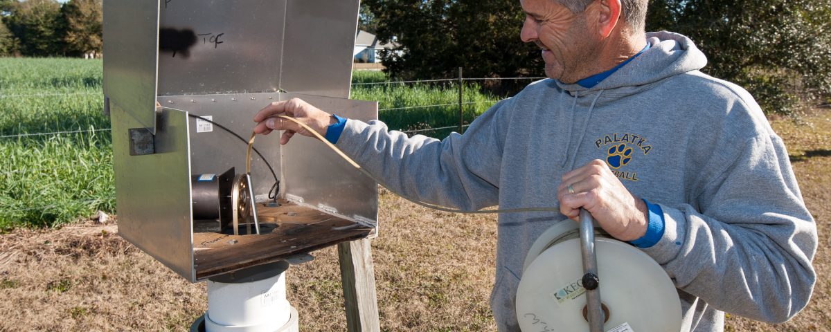 District staff measuring water level in monitoring well