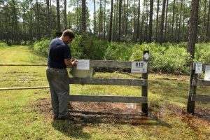 District staff putting up property closure notice on entrance to conservation area