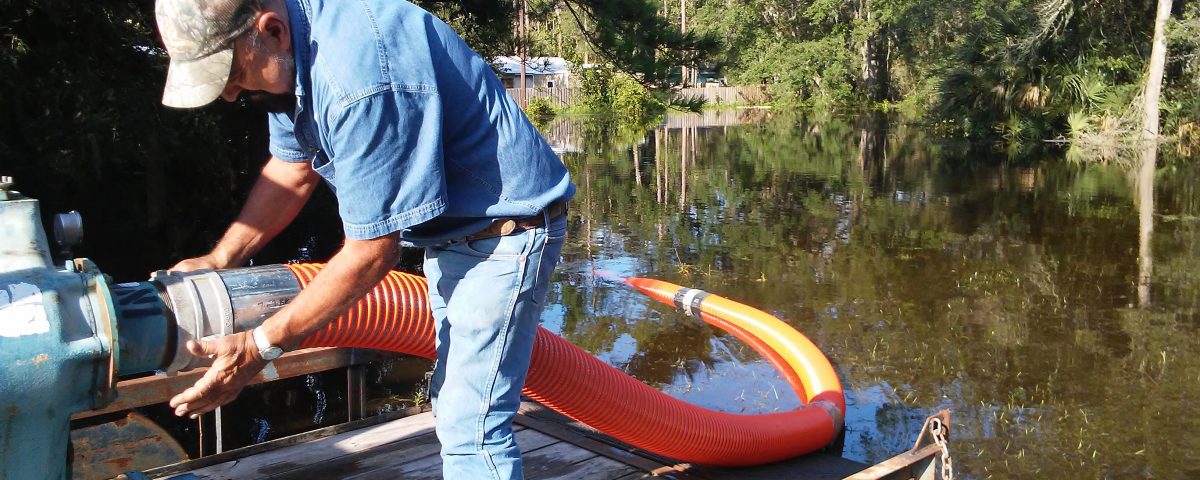 District staff connecting up a pump to alleviate flooding