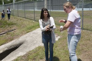 Students collecting water samples at a stormwater pond as part of the Blue School Grant program