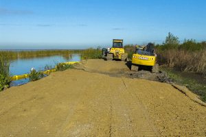 Tractors working to stabilize a levee along Lake Apopka