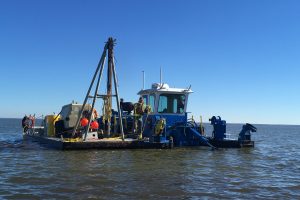 Perople working on a dredging barge on Lake Apopka