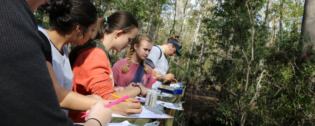Students testing water and recording data at Julington Creek