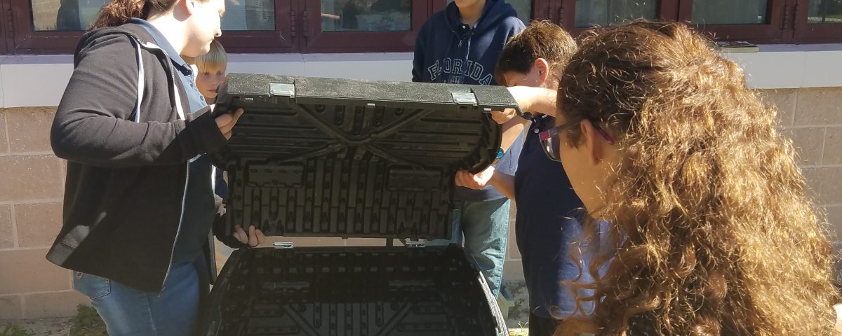 Students installing a composter at their school