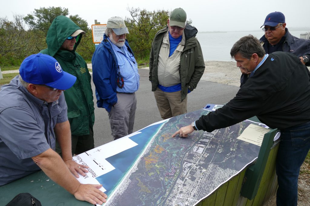 Mosquito Lagoon tour District staff review a map of the Mosquito Lagoon on a tour