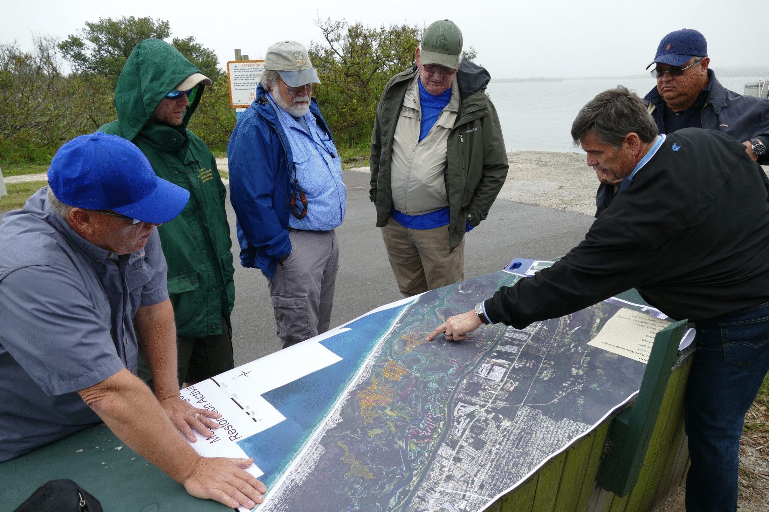 District staff review a map of the Mosquito Lagoon on a tour