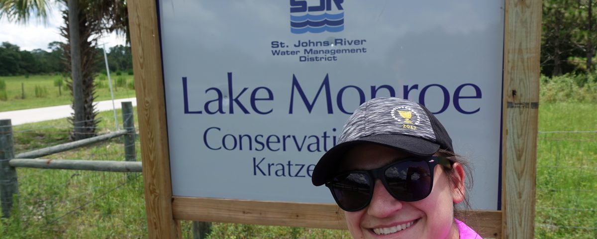 Selfie of a woman in front of the Lake Monroes Conservation Area entrance sign