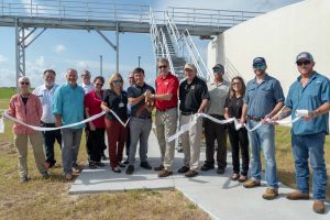 Lisa Kelley and shreholders cutting the ribbon at the Eustis Wastewater Treatment Plant Ribbon Cutting Event