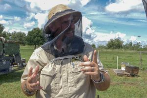 Man in bee keeper protective gear
