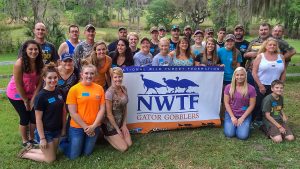 Group of people with a National Wild Turkey Federation banner