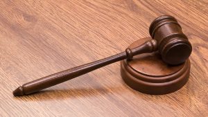 A gavel resting on a sounding block