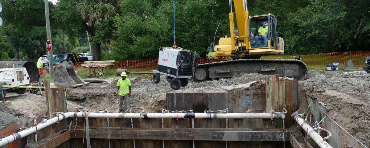 Excavator lowering equipment into a stormwater baffle box