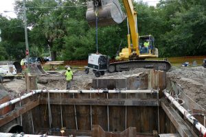 Excavator lowering equipment into a stormwater baffle box
