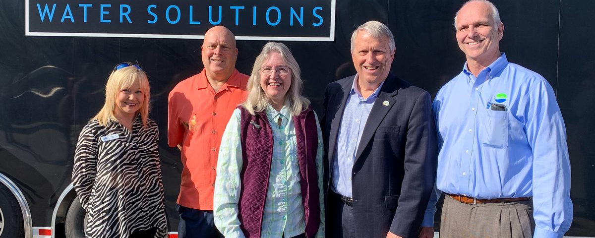 Five people standing infront of a trailer with a Phosphorus Free Water Solutions sign
