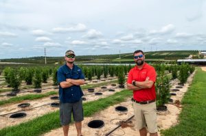 Todd Gentry and Austin Spivey standing in their field
