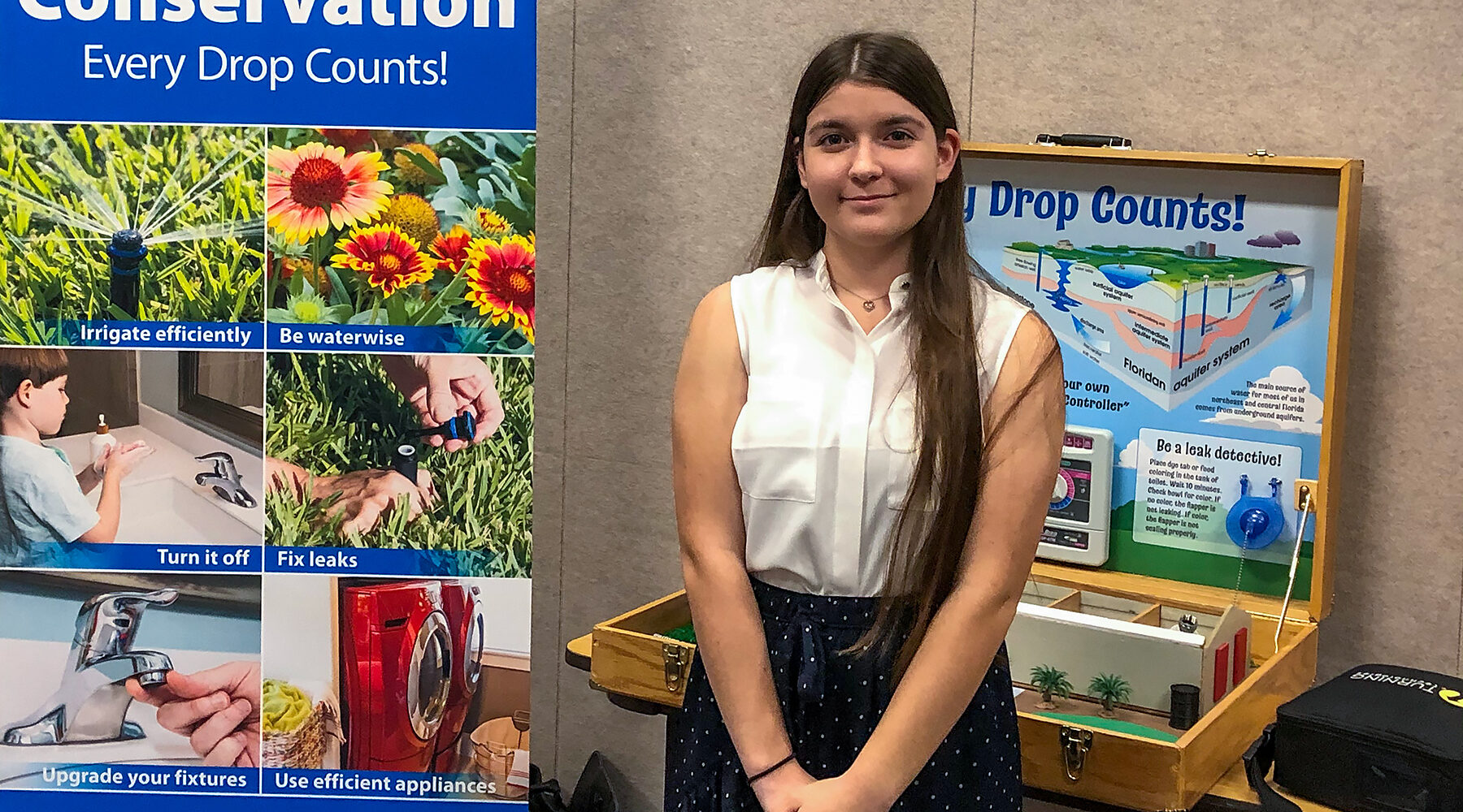 Madison Aprandini standing with a water conservation display