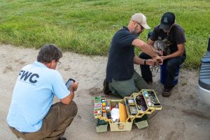 Tim Dellinger carefully fits a leg band on a Sandhill crane