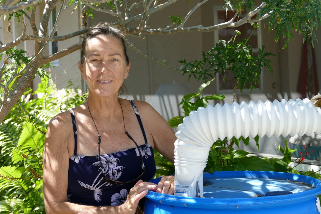 Abbey Calhoun reduces her household water bill by using a rain barrel to collect rainwater that she uses to water her garden.