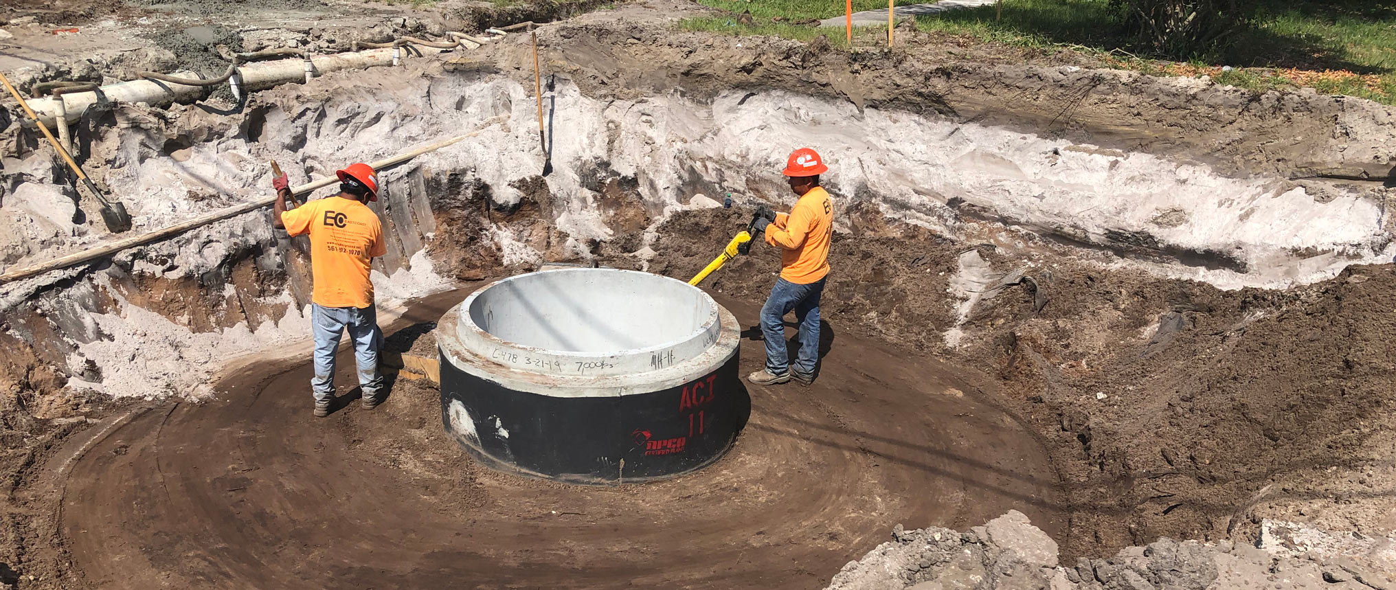 Construction workers installing sewer pipes