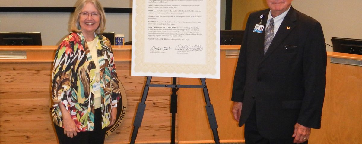 Dr. Ann Shortelle and Gen. Douglas Burnett standing next to a signed proclamation