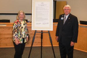 Dr. Ann Shortelle and Gen. Douglas Burnett standing next to a signed proclamation