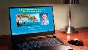 Computer on desk showing a webinar