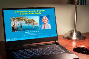 Computer on desk showing a webinar