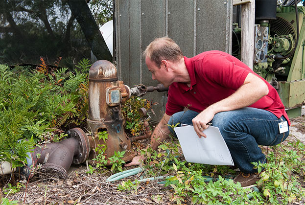 Man in a red shirt inspecting equipment