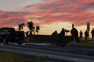 An angler backs their boat into the water at dawn