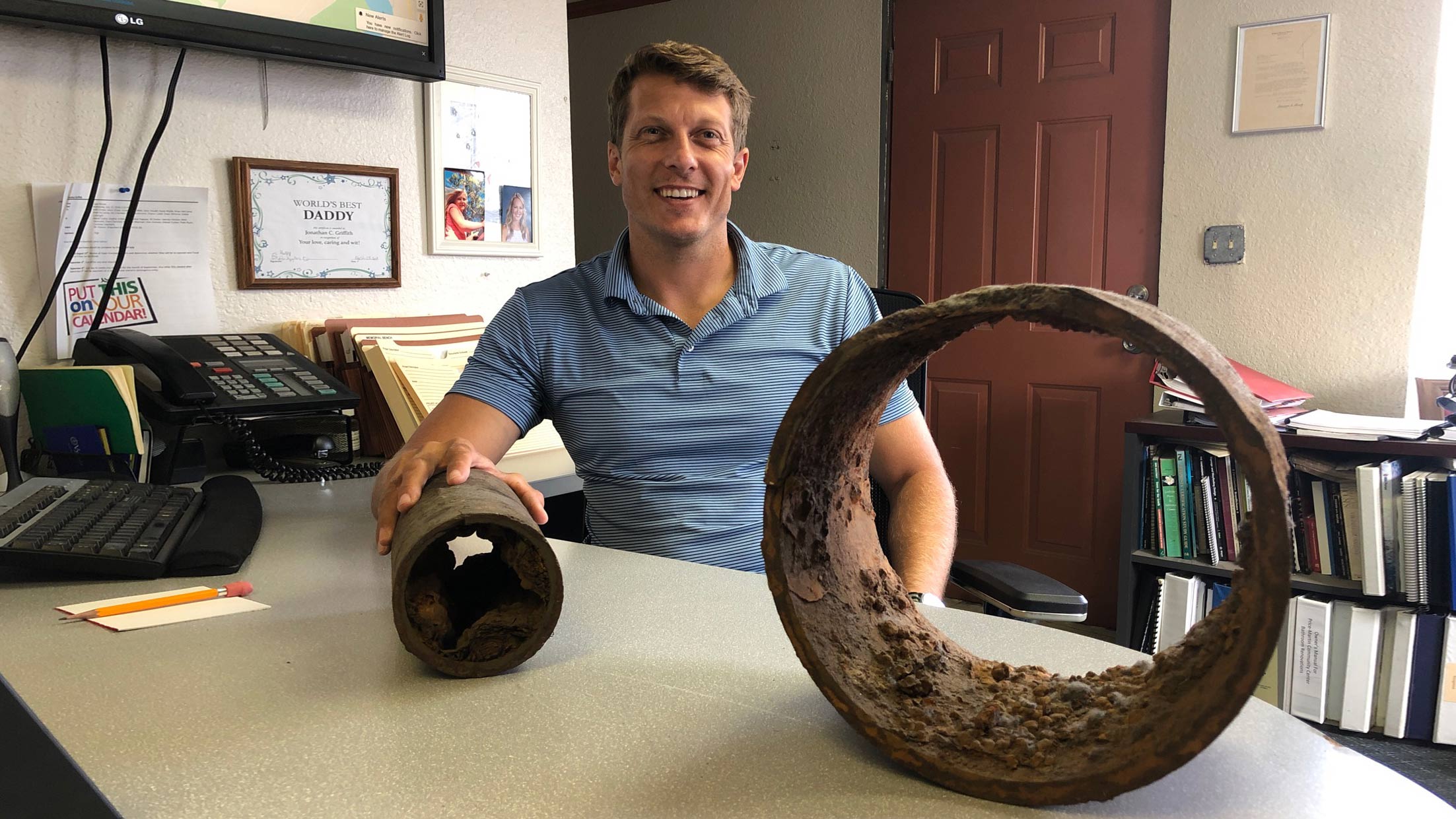 Jonathan Griffith displays a piece of cast iron pipe in his office