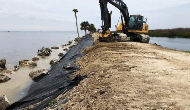 Excavator working on a water control levee