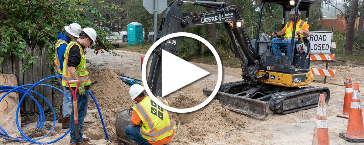 Four district employees working it a hole to fix water pipes