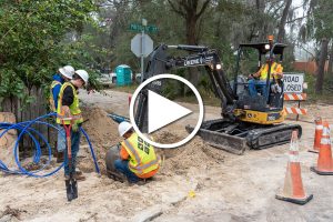 Four district employees working it a hole to fix water pipes
