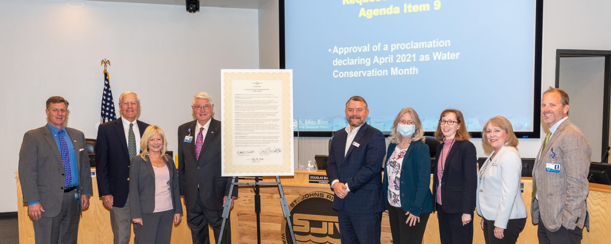 Governign board members with poster sized water conservation month proclamation