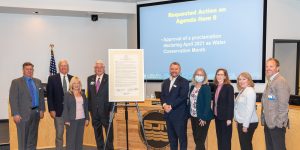 Governign board members with poster sized water conservation month proclamation