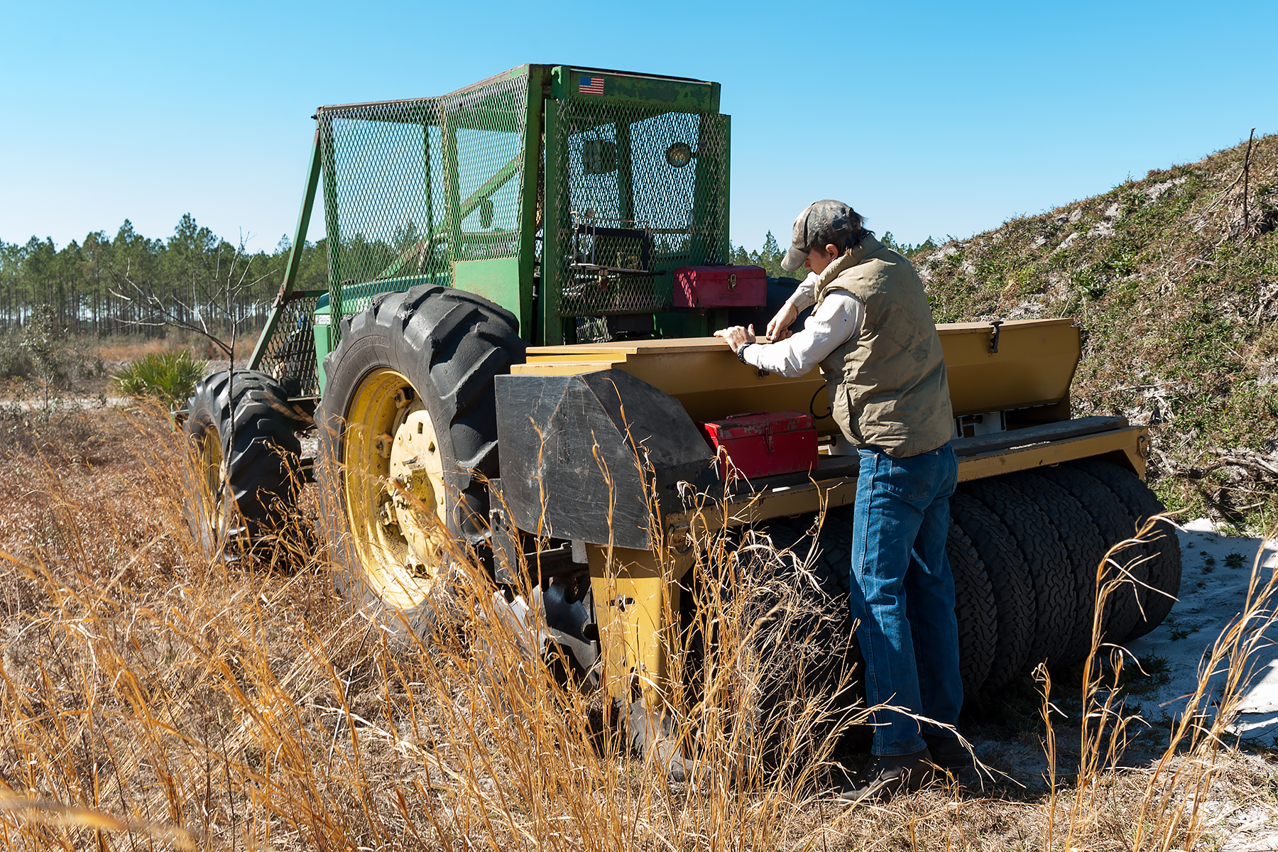 District staff loading wiregrass in a tractor