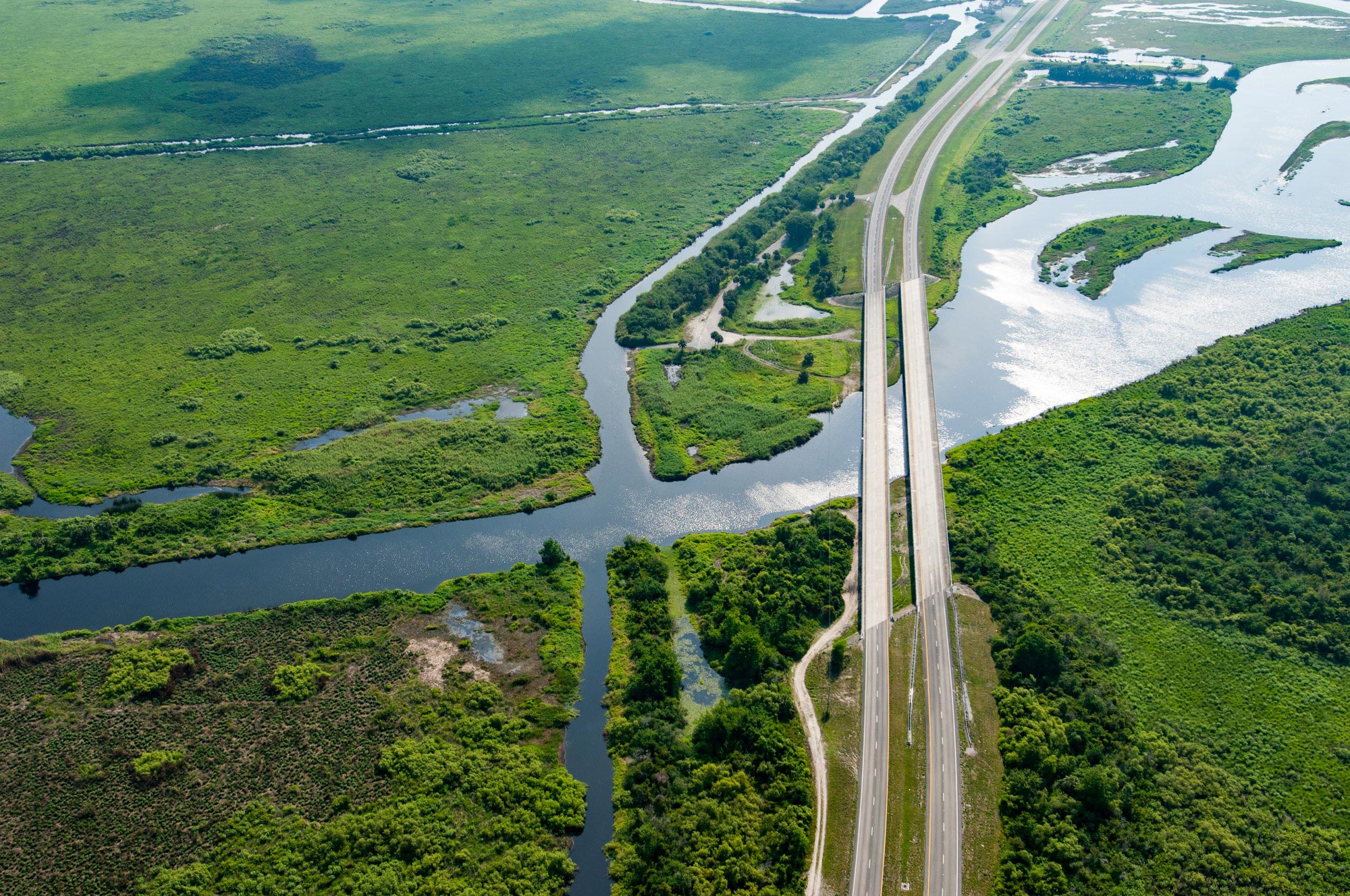 Aerial view of a road next to a stream