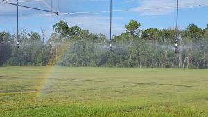 A small rainbow on a farm field