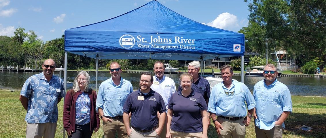 District staff and board members standing in front of a portable tent