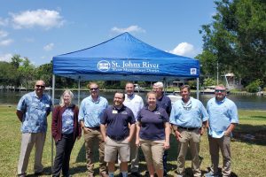 District staff and board members standing in front of a portable tent