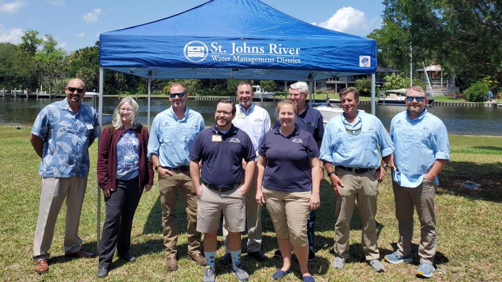 District staff and board members standing in front of a portable tent