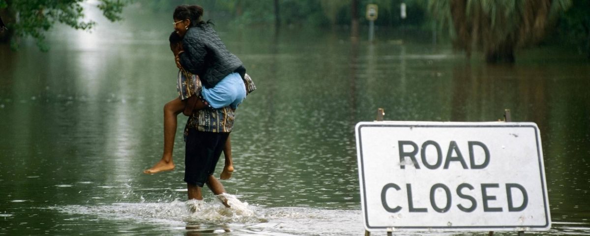 A person carying someone through highwaters