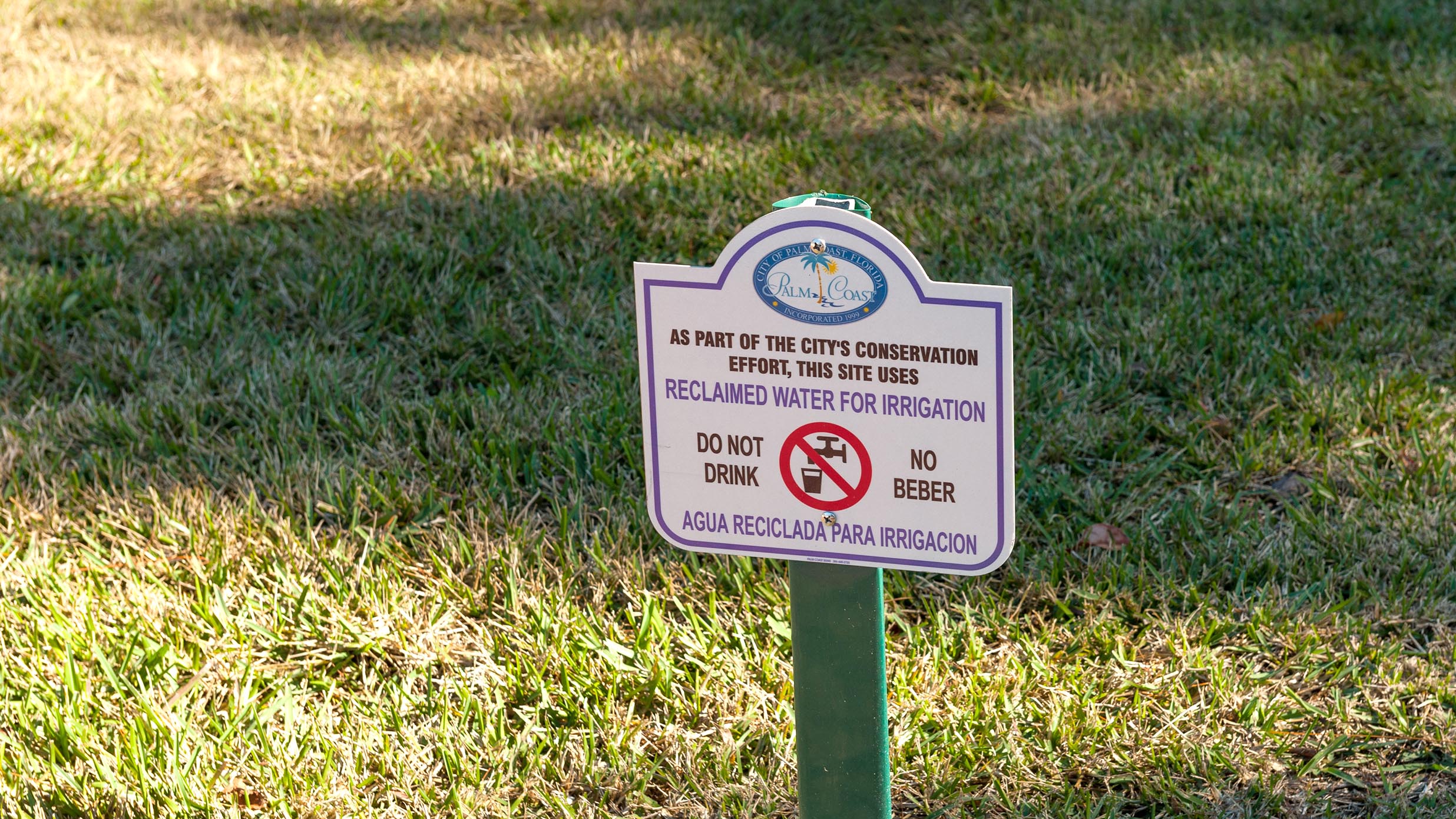 "Don't drink" sign on a grass lawn