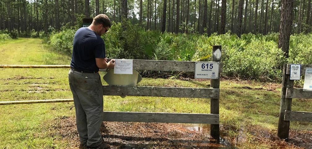 District employee putting a sign up on a fence